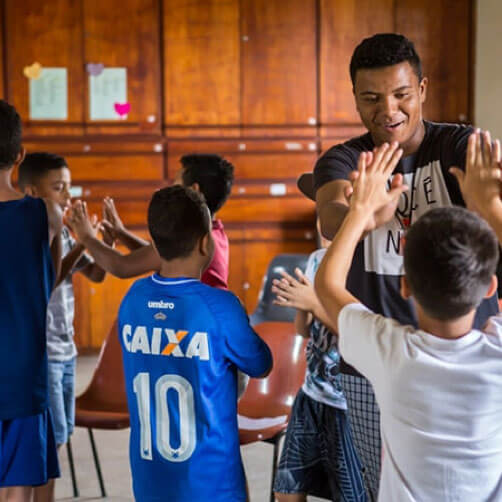 An adult volunteer receives a high five during some time in a gymnasium. Photo courtesy Connectional Table. An adult volunteer receives a high five during some time in a gymnasium. Photo courtesy Connectional Table.