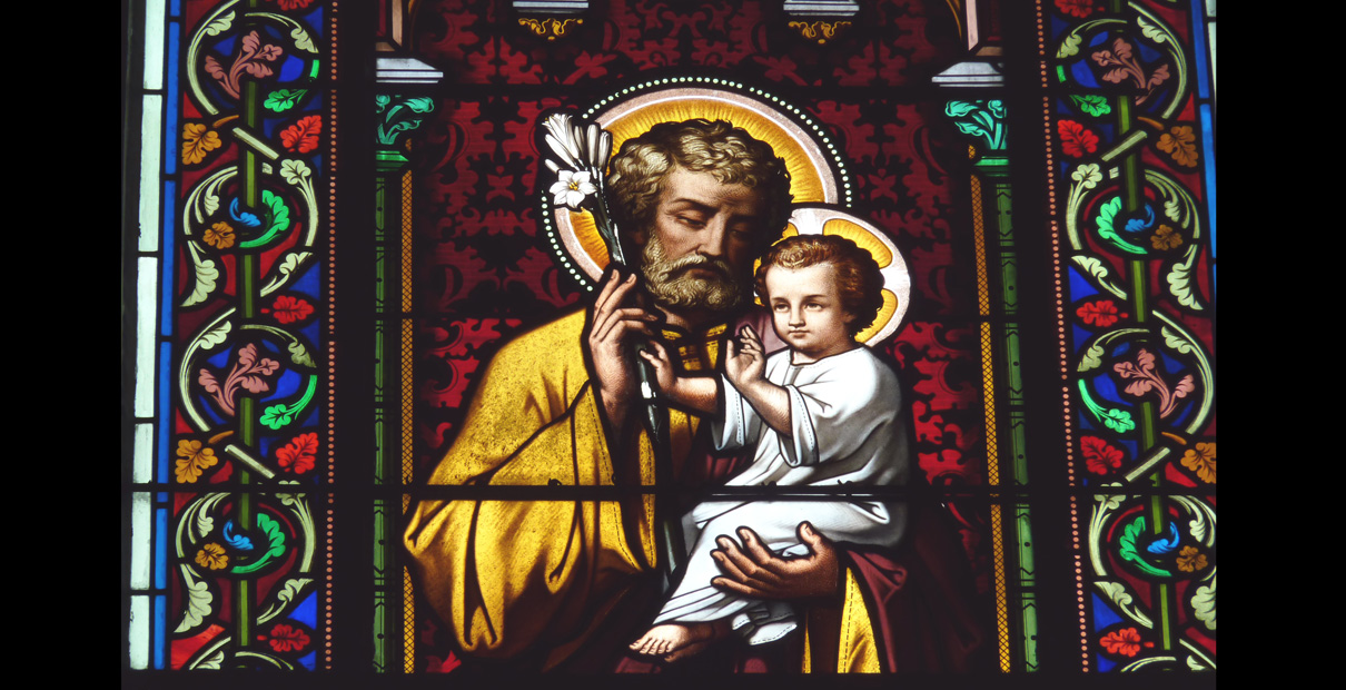 Detail of stained glass window of St. Joseph and Jesus from Church Sainte Marguerite in Le Vesinet in the Departement Yvelines, Ile-de-France. Photo by Reinhardhauke, Wikimedia Commons.