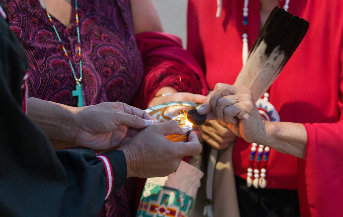 Native American leaders prepare charcoal that will be used to burn cedar during a prayer service for immigrant children held at the Casa Padre detention. Many Native Americans believe that cedar smoke carries their prayers to God. Photo by Mike DuBose, UMNS.