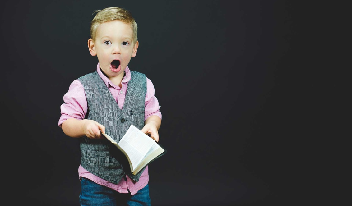 little boy pink shirt holding bible