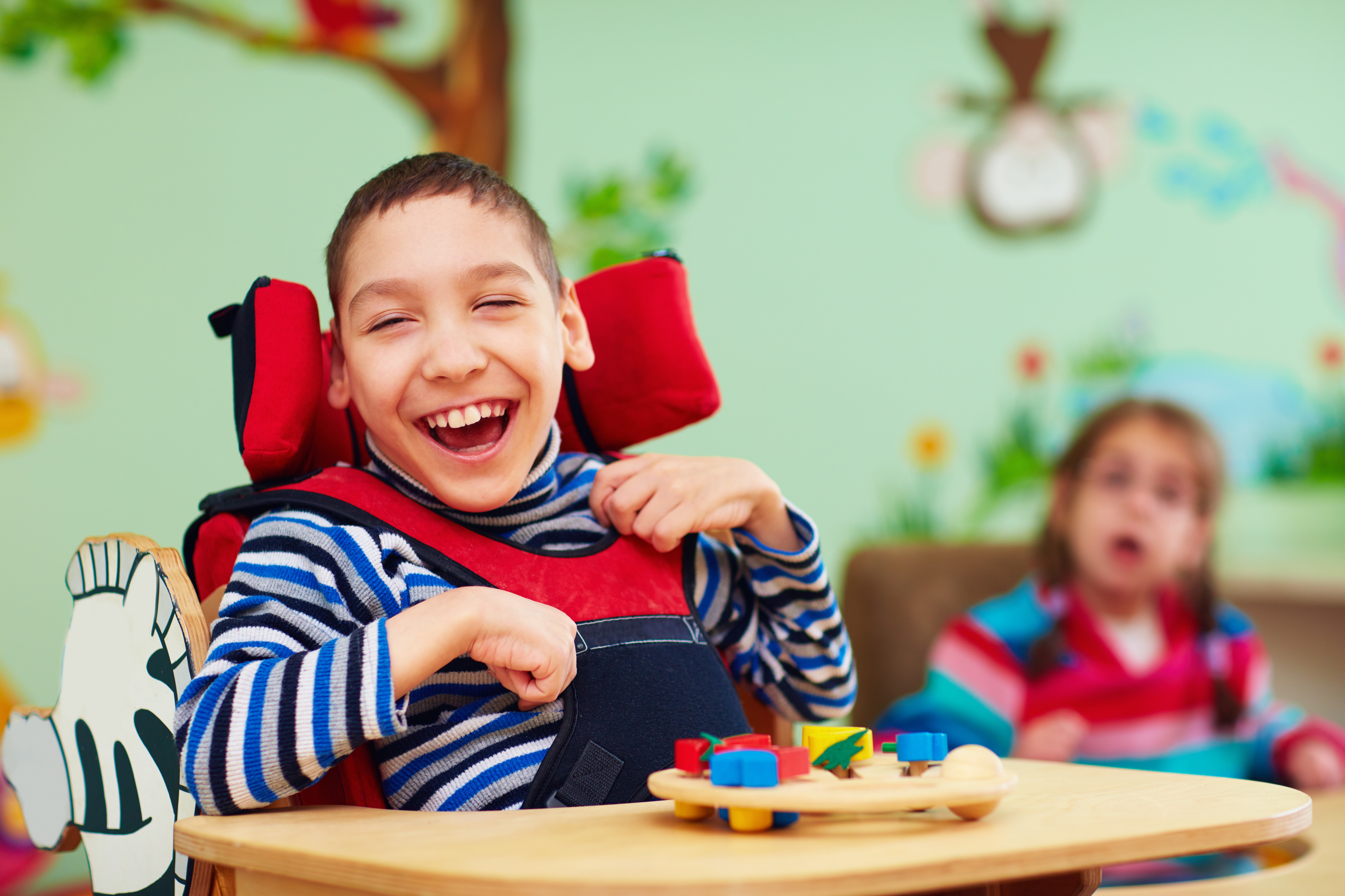 Cheerful boy with disability at rehabilitation center for kids with special needs. Photo by olesiabilkei, iStockPhotos.com.