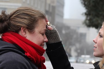 Ingrid McIntyre receives ashes from street chaplain, Lindsey Krinks. About 30 people gathered as a community to share in the Ash Wednesday liturgy and to raise awareness of those suffering from homelessness and poverty. McIntyre is a member of Christ United Methodist Church in Franklin, Tenn. A file photo by Kathleen Barry, United Methodist Communications.