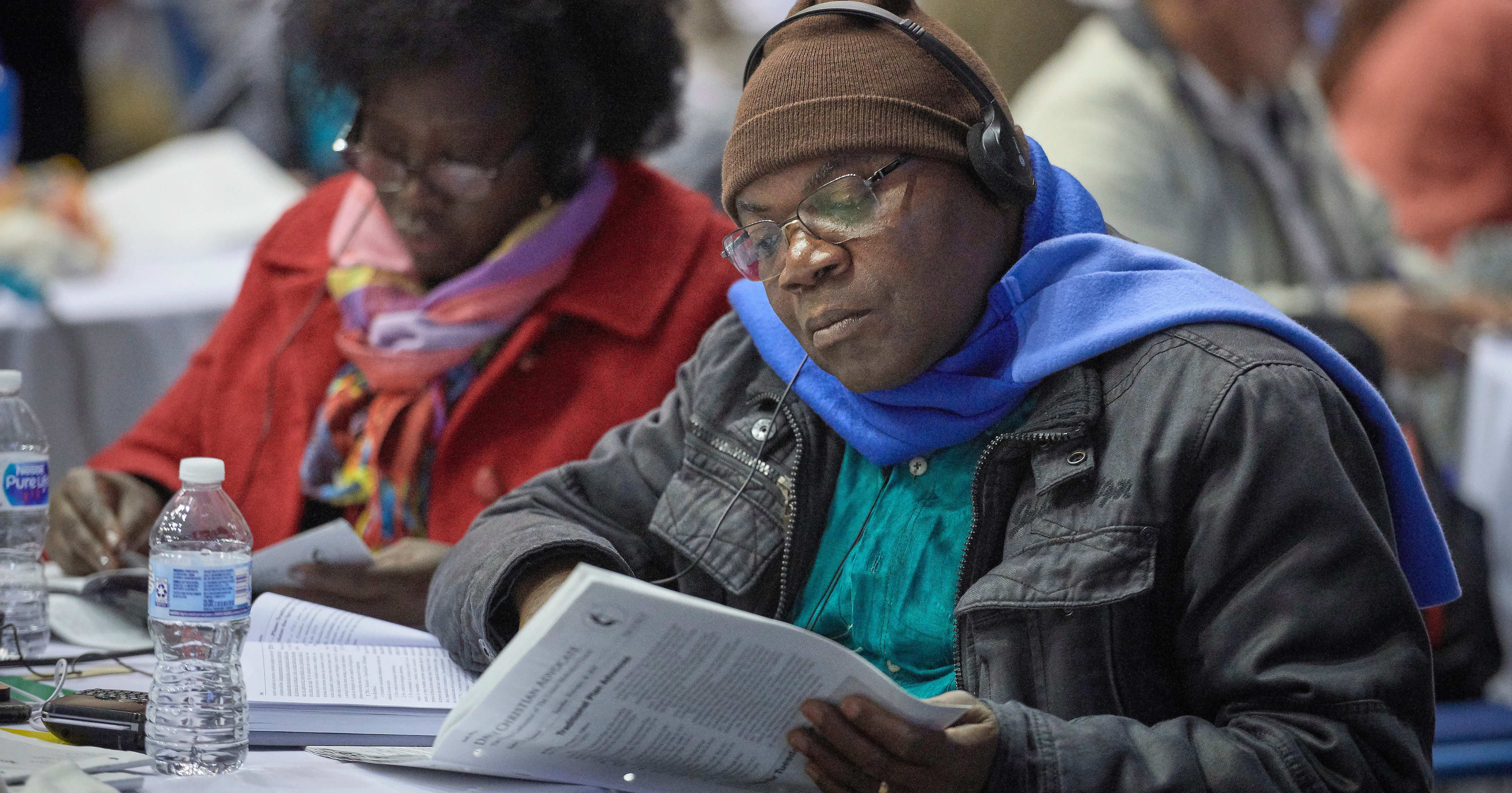 A delegate studies a printed version of proposed legislation before a February 26, 2019, vote to strengthen denominational policies about homosexuality. Photo by Paul Jeffrey, UM News.