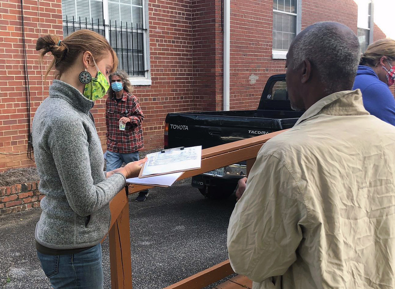 Camille Cody (left), a volunteer with Centenary Community Ministries Inc. in Macon, Ga., looks over paperwork while talking with a man about the U.S. government’s stimulus check program. Volunteers have to date helped more than 50 homeless and poor people fill out the complicated tax forms and applications required to receive a check. Photo courtesy of Centenary Community Ministries Facebook page.