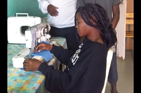 Winnet Mandikisi, 19, works at a sewing machine at Home of Hope, the orphanage at Nyadire United Methodist Mission in Mutoko, Zimbabwe. Mandikisi, a college student, has been leading efforts to teach fellow orphans how to make masks to fight against COVID-19. Photo by Chenayi Kumuterera, UM News.