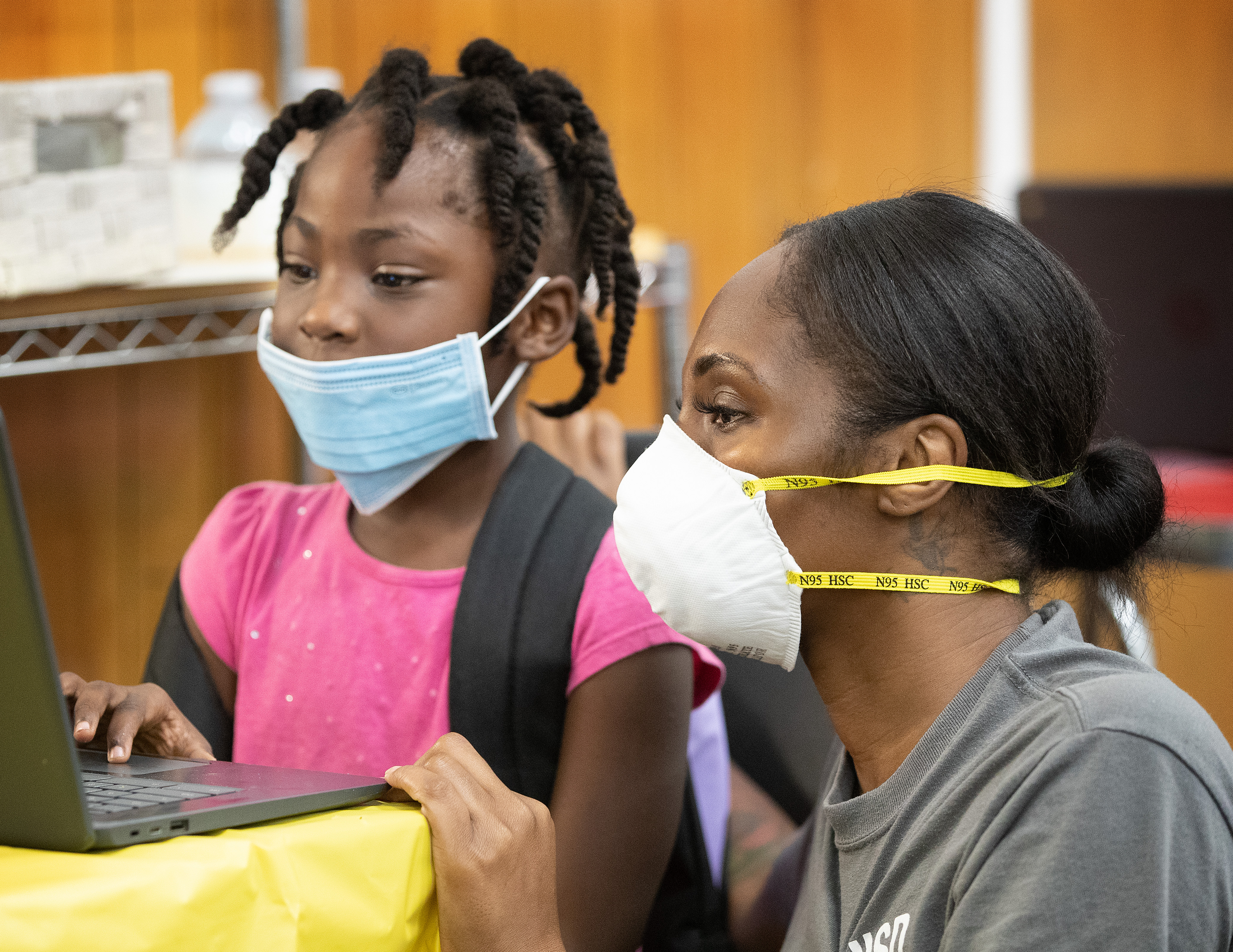 Dominique McCray of the Houston Independent School District helps 1st grader Kha’lyia Rogers with her schoolwork during the first day of the Sanctuaries of Learning program at Trinity United Methodist Church in Houston. The program, started by the Texas Conference of The United Methodist Church, offers a safe space, internet access and other resources in area churches, allowing parents to return to work and their children to continue their education during the COVID-19 pandemic. Photo by Mike DuBose, UM News.