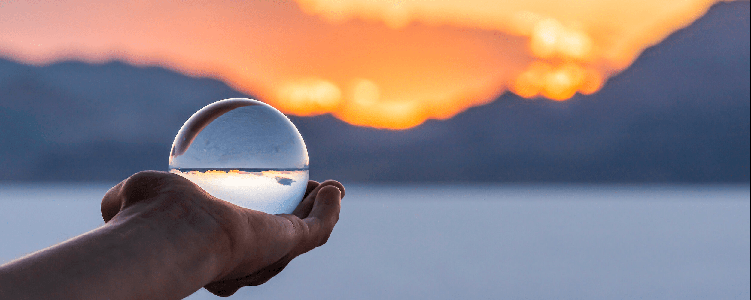 Hand holding a crystal globe with sunset in background. Image by krblokhin, iStockPhoto.com. Image courtesy of the Connectional Table. Hand holding a crystal globe with sunset in background. Image by krblokhin, iStockPhoto.com. Image courtesy of the Connectional Table.