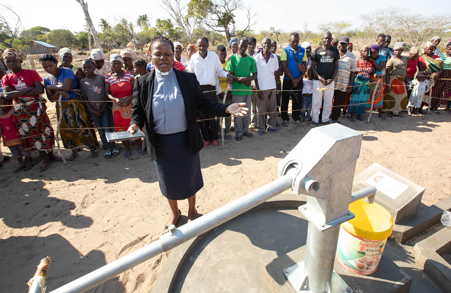 The Rev. Hortencia Bacela prays over a new water well during dedication ceremonies in Mudembelane village near Homoine, Mozambique. Photo by Mike DuBose, UM News.