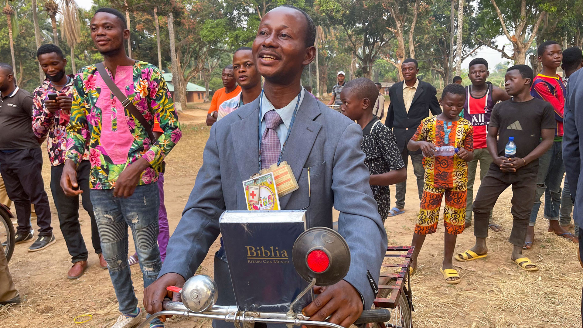 The Rev. Ngongo Asaka smiles after receiving a new bicycle and a Bible as tools for evangelism in Tunda, Congo. Asaka was among 52 pastors of rural United Methodist churches in the area who received the gifts from Crosspoint, a United Methodist church in Niceville, Fla. Photo by Chadrack Londe, UM News.