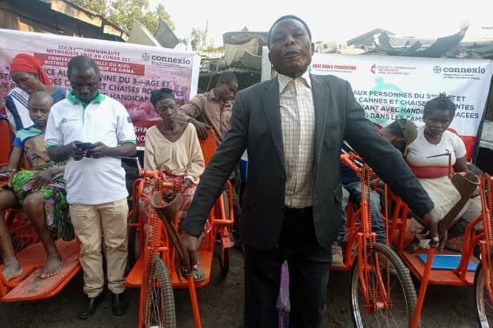 Samuel Kasororo stands with mobility aids provided by The United Methodist Church in eastern Congo. Kasororo, a United Methodist father of six, lost his right leg during war in 2006. The gift will enable him to continue his evangelism work, he said. Photo by Philippe Kituka Lolonga, UM News.