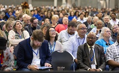 Visitors to the United Methodist General Conference in Charlotte, N.C., watch the proceedings on overhead video monitors. Photo by Mike DuBose, UM News.