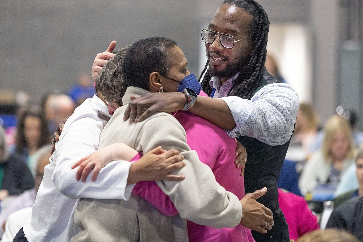 El Rev. Jay Williams a la derecha, abraza a sus compañeros/as delegados/as después de que la Conferencia General Metodista Unida reunida en Charlotte, Carolina del Norte, votara el 1 de mayo para eliminar la prohibición de larga data de La Iglesia Metodista Unida sobre la ordenación de clérigos/as que son “homosexuales practicantes declarados”. Foto de Mike DuBose, Noticias MU.