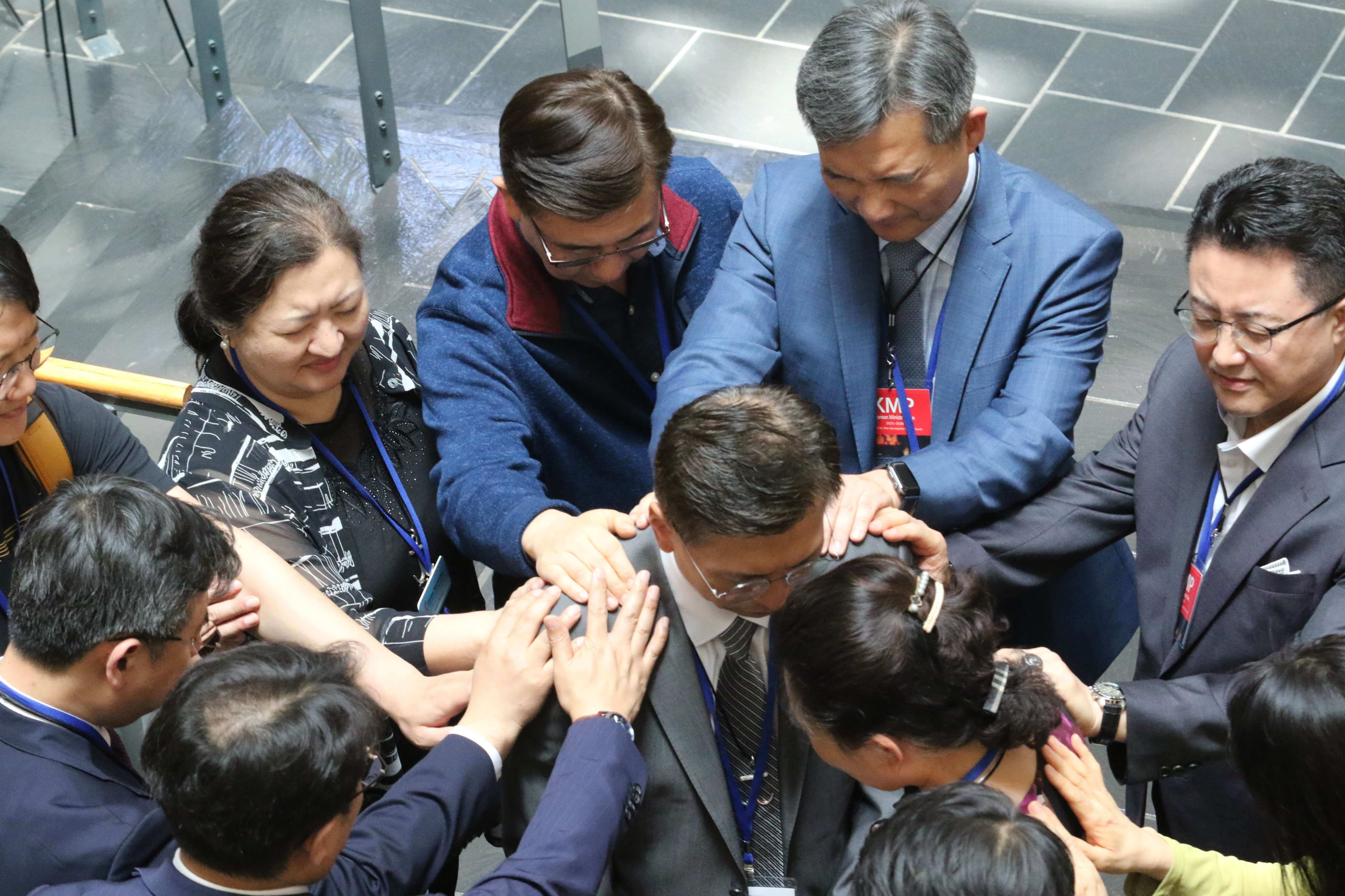 연합감리교회 한인총회는 2024년 5월 2일 노스캐롤라이나 샬럿에서 열린 연합감리교회 2024 총회에서, 연합감리교회 세계선교부 소속 장기선교사 140명 전원을 향후 3년간 후원하기로 약속했다. 총회 중, 이창민 목사를 비롯한 한인총회 임원들과 세계선교부 주디정 목사 등이 새롭게 선교지로 파송 받은 16명의 선교사 중 라오스로 파송 받은 김데이빗 목사와 이소라 선교사를 위해 기도하고 있다. 사진, 김응선 목사, 연합감리교뉴스.