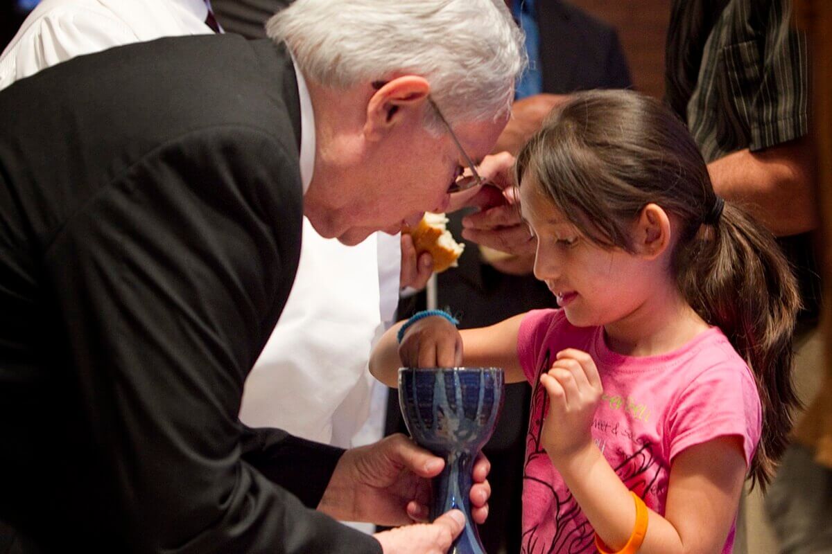 A child participates in a communion service at MARCHA