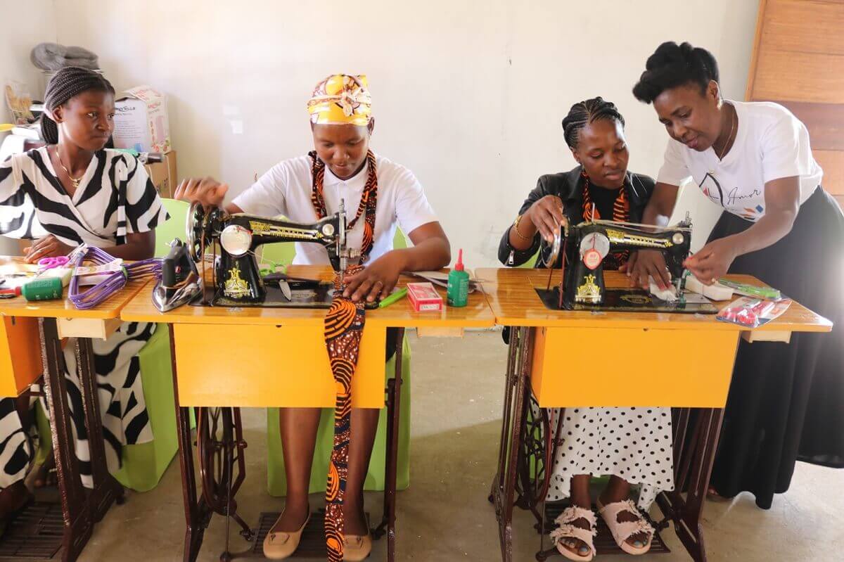 Cutting and design students receive instruction from Rute Uthui. The Cutting, Sewing and Cooking Project empowers women and girls with knowledge that can lead to income generation.